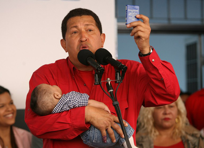 This file picture shows Venezuelan president Hugo Chavez holding his grandson and a copy of the Venezuelan constitution, during a press conference after voting at a polling station 02 December 2007 in Caracas. (AFP Photo / Yuri Cortez)
