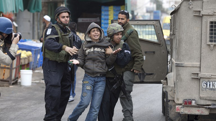 Israeli troops arrest a young Palestinian stone thrower in the West Bank town of Hebron on February 25, 2010. (AFP Photo / Marco Longari)