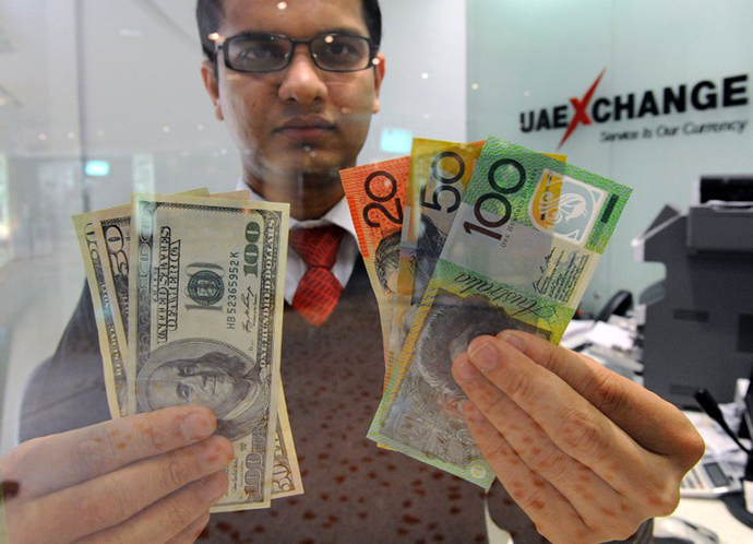 Money changer displays a selection of US dollars and Australian notes. (AFP Photo / Torsten Blackwood)