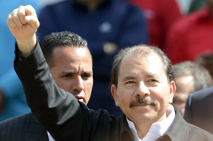 Nicaragua's President Daniel Ortega raises his clenched fist in salutation during the funeral of Venezuela's President Hugo Chavez in Caracas, on March 8, 2013. (AFP Photo/Juan Baretto)