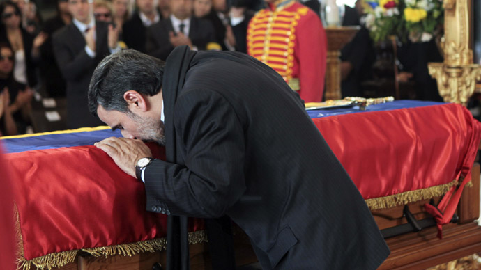 This handout picture released by Venezuelan presidency press office shows Iranian President Mahmoud Ahmadinejad greeting the coffin of late Venezuelan President Hugo Chavez in Caracas, on March 8, 2013. (AFP Photo/Presidencia/Miguel Angel Angulo)