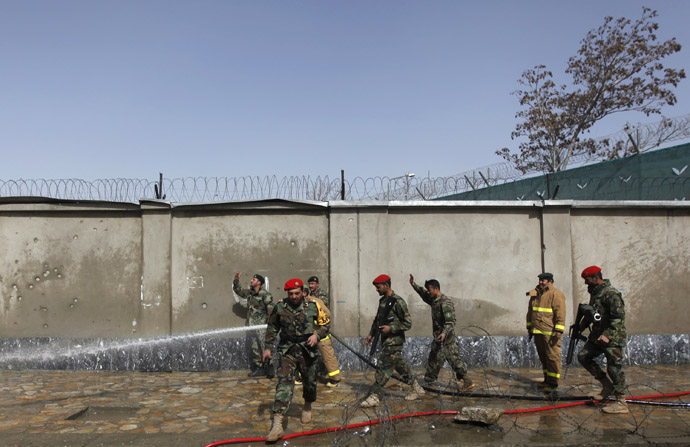 Afghan firefighters wash debris off the road at the site of a suicide attack in Kabul March 9, 2013 (Reuters/Mohammad Ismail)