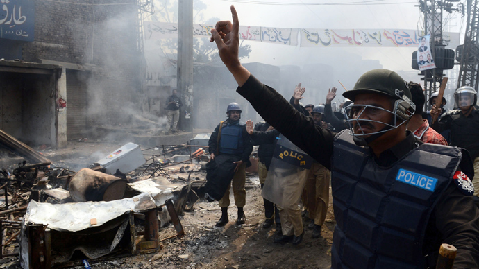Pakistani riot police gesture during a protest by Muslim demonstrators over alleged blasphemous remarks by a Christian in a Christian neighborhood in Badami Bagh area of Lahore on March 9, 2013 (AFP Photo)