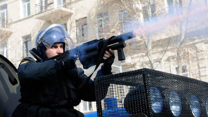 A riot policeman fires tear gas to disperse people during a rally against soldiers death in the national Azerbaijan's army in Baku on March 10, 2013 (AFP Photo / Tofik Babayev)