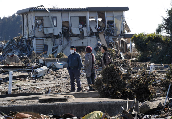 People walk through debris in the aftermath of a tsunami in Minamisoma, Fukushima prefecture, on March 12, 2011. (AFP Photo/Toru Yamanaka)