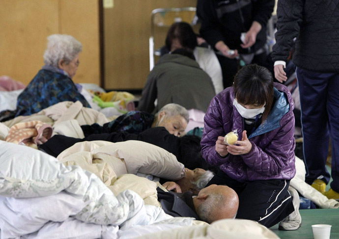 A staff member (R) of a nursing home takes care of elderly people at a shelter in Tamura after they were evacuated from the area near the nuclear plants in Fukushima prefecture on March 13, 2011 two days after a massive 8.9 magnitude quake and tsunami hit the region. (AFP Photo/JiJi Press)