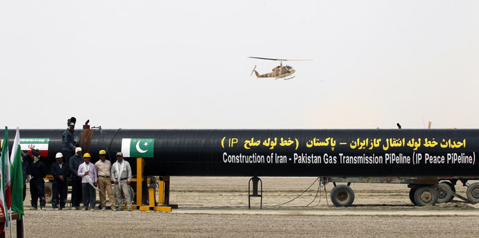 Irani workers stand near as a security helicopter lands near the pipeline during a groundbreaking ceremony to mark the inauguration of the Iran-Pakistan gas pipeline, in the city of Chahbahar in southeastern Iran March 11, 2013. (Reuters/Mian Khursheed)