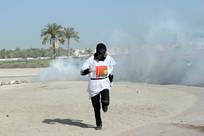A protester runs to take cover from tear gas fired by riot police during early hours of clashes in the village of Sanabis, west of Manama March 14, 2013 (Reuters / Hamad I Mohammed)