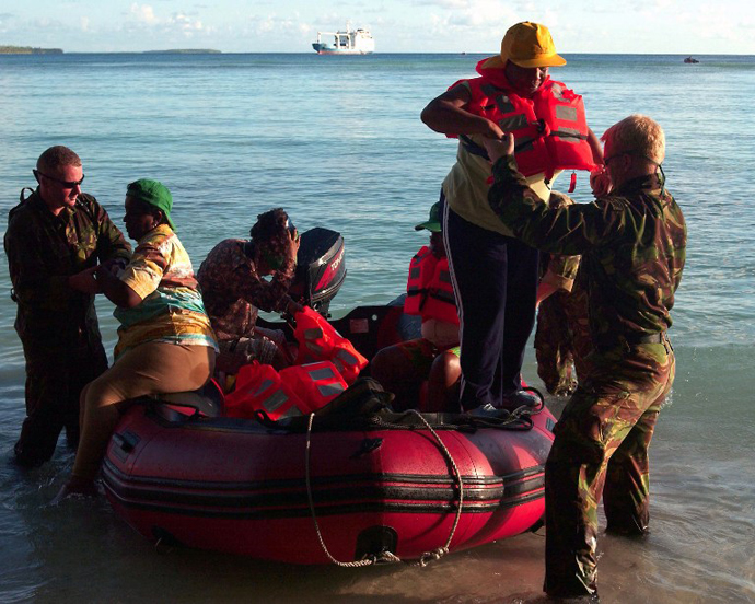 Foreign and Commonwealth Office handout picture dated 04 April and issued 06 April 2006 shows Royal Marines helping a group of Chagossians as they arrive on Peros Banhos, part of the Chagos archipelago. (AFP Photo / LA Terry Boughton)