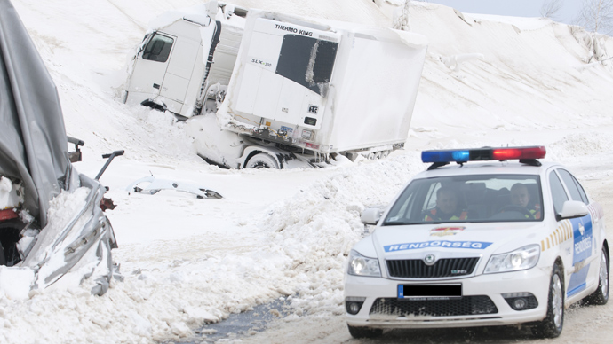 A police car arrives at the site of an accident involving a truck and cars at the E71 motorway, nearby the Croatian, Slovenian and Hungarian borders on March 15, 2013 a day after a heavy snow storm hit the area (AFP Photo / Szilard Gergely)