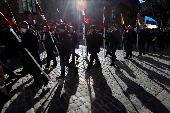 People hold Latvian and Estonian (R) national flags during the annual procession commemorating the Latvian Waffen-SS (Schutzstaffel) unit, also known as the Legionnaires, in Riga March 16, 2013.(Reuters / Ints Kalnins)
