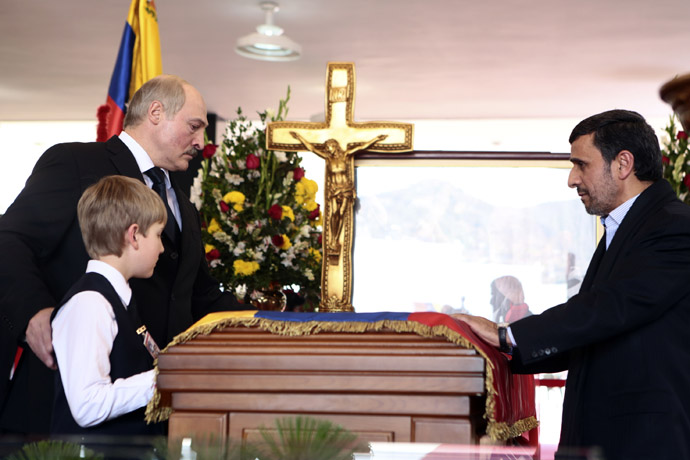 This handout picture released by Venezuelan presidency press office shows Iranian President Mahmoud Ahmadinejad (R), Belarusian President Alexander Lukashenko (L) and his son Nikolai paying their last respects to the coffin of late Venezuelan President Hugo Chavez in Caracas, on March 8, 2013. (AFP Photo/Miguel Angel Angul)