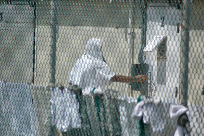 An inmate reaches near his cell at the Camp Delta detention center for terrorism suspects at the U.S. Naval Base at Guantanamo Bay, Cuba (Reuters / Randall Mikkelsen)