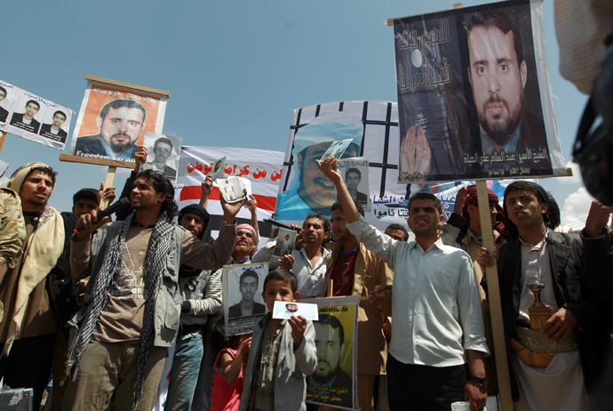 Relatives of Yemeni inmates held in the US detention center "Camp Delta" at the US Naval Base in Guantanamo Bay, Cuba, brandish their portraits during a protest to demand their release, outside the American Embassy in Sanaa, on April 1, 2013 (AFP Photo / Mohammed Huwais)