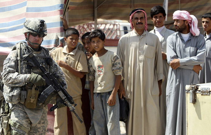 A U.S. soldier stands next to Iraqi residents as he patrols in Mosul, 390 km (240 miles) north of Baghdad September 5, 2010. (Reuters/Saad Shalash)