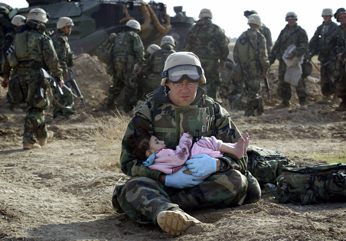 U.S. Navy Hospital Corpsman HM1 Richard Barnett, assigned to the 1st Marine Division, holds an Iraqi child in central Iraq in this March 29, 2003 file photo. (Reuters/Damir Sagolj)