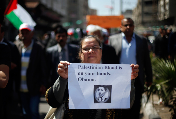 A Palestinian woman holds a sign during a protest against the visit of U.S. President Barack Obama, in Gaza City March 20, 2013 (Reuters / Mohammed Salem)