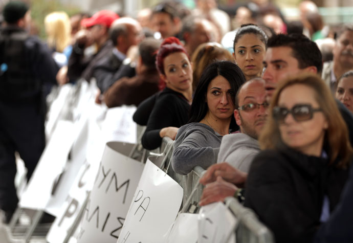 Employees of Cyprus Laiki (Popular) Bank gather as they protest outside the parliament in Nicosia.(AFP Photo / Patrick Baz)
