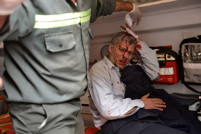An Egyptian man is treated in an ambulance after being injured during clashes part of a protest of members of Egyptian Muslim brotherhood in front the party's headquarters in Cairo on March 22, 2013. (AFP Photo / Haled Desouki)