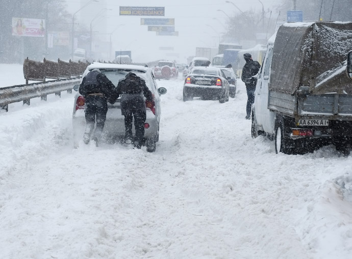 Motorists push a car that is stuck in snow during a blizzard in Ukrainian capital Kiev March 23, 2013. (Reuters)