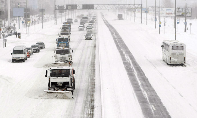 A convoy of snow clearing vehicles work along a main road after a heavy snowfall in Kiev, March 23, 2013. (Reuters)