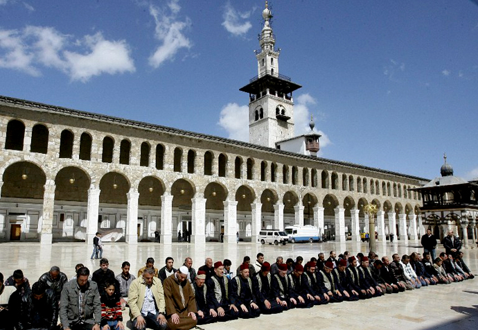 People pray in the Omayyad mosque courtyard during the funeral ceremony of Sunni Muslim cleric Mohamed Saeed al-Bouti, who died in a suicide bomb attack, on March 23, 2013 in the Syrian capital Damascus. (AFP Photo / Louai Beshara)