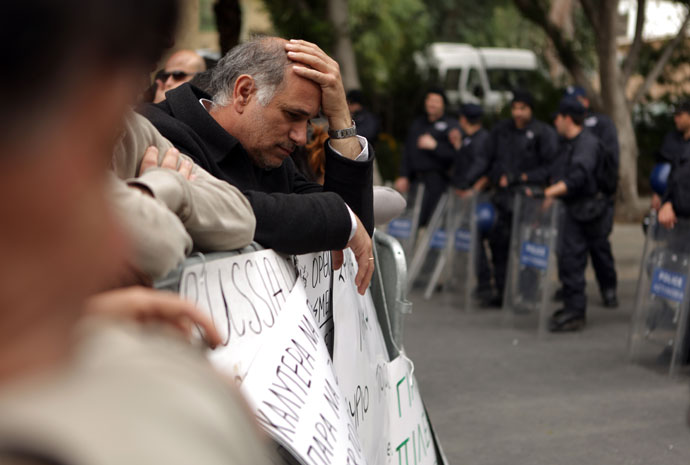 An employee of Cyprus Laiki (Popular) Bank reacts as he takes part in a protest outside the parliament in Nicosia.(AFP Photo / Patrick Baz)