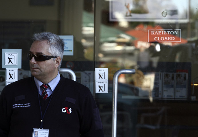 A security man stands outside a closed Laiki bank branch in the Cypriot capital, Nicosia, on March 28, 2013, ahead of their reopening after an unprecedented 12-day lockdown. (AFP Photo)
