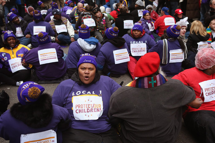 Demonstrators prepare to be arrested while protesting school closings on March 27, 2013 in Chicago, Illinois. More than 1,000 demonstrators held a rally and marched through downtown to protest a plan by the city to close more than 50 elementary schools, claiming it is necessary to rein in a looming $1 billion budget deficit. (Scott Olson/Getty Images/AFP)