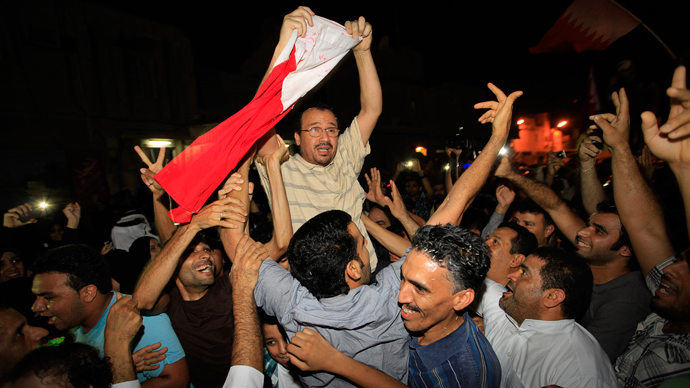 Bahraini doctor Ali al-Akri holds up a Bahrain flag as he is embraced by anti-government protesters upon arriving home in Manama, September 7, 2011 (Reuters / Hamad I Mohammed)