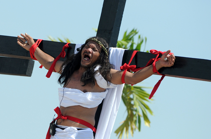 Philippine Christian devotee Ruben Enaje grimaces in pain after being nailed to the Cross by men dressed as Roman soldiers during a re-enactment of the crucifixion of Jesus Christ on Good Friday in San Fernando City, Pampanga province, north of Manila on March 29, 2013 (AFP Photo / Noel Celis)