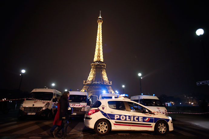 People walk past police cars blocking the way to the Eiffel Tower in Paris on March 30, 2013. (AFP Photo / Thomas Coex)