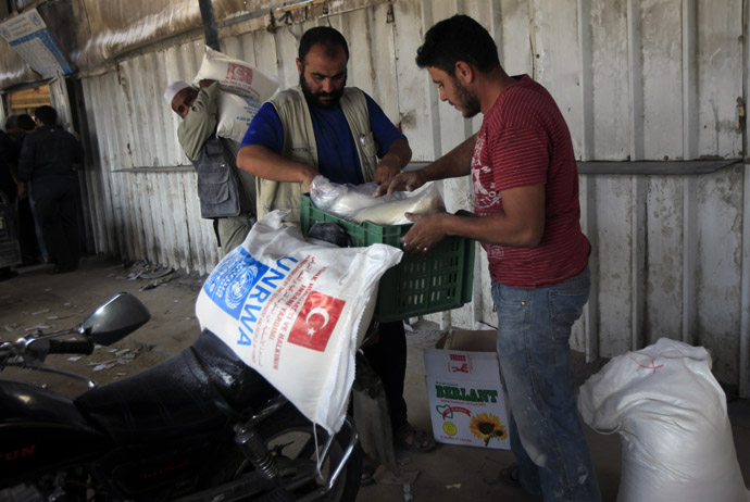 Palestinians collect food supplies from the United Nations Relief and Works Agency (UNRWA) headquarters in Rafah in the southern Gaza Strip (AFP Photo/Said Khatib)