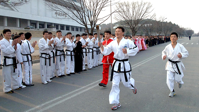 Athletes attend a torch-lighting ceremony for the 5th International Martial Arts Games on Chongchun Street in Pyongyang April 3, 2013. (AFP Photo / KCNA)