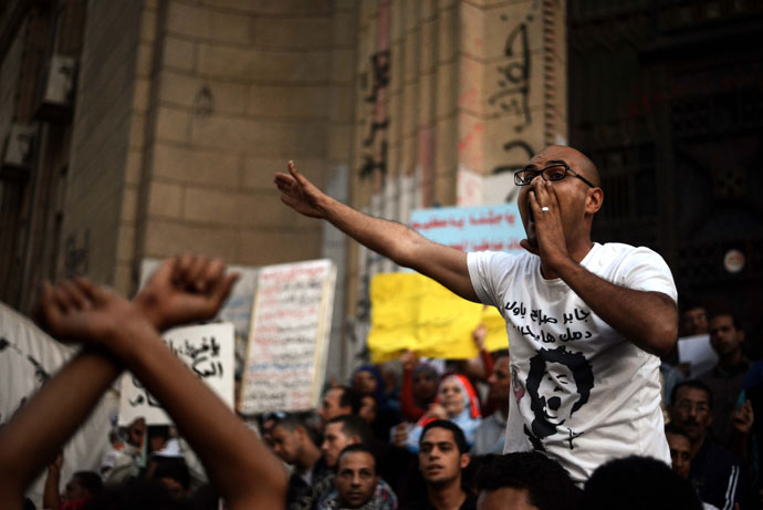 An Egyptian supporter of the April 6 movement is carried by protesters as he shouts slogans against the president and the Muslim brotherhood during a demonstration outside the Superior Court building in Cairo on April 6, 2013.(AFP Photo / Gianluigi Guercia)
