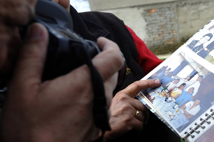A neighbour shows a family album bearing a picture of the alleged killer in the village of Velika Ivanca, 40 kilometres south of capital Belgrade, on April 9, 2013, where a man shot dead 13 relatives and neighbours, including a two-year-old child, in the country's worst killing spree in two decades.(AFP Photo/Andrej Isacovic)