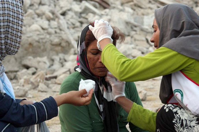 An Iranian woman receives medical treatment from aid workers in the town of Shonbeh, southeast of Bushehr, on April 9, 2013. (AFP Photo / Mohammad Fatemi)
