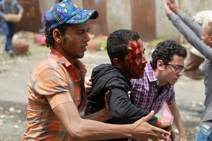 Egyptian anti-military protesters help a wounded demonstrator during clashes in the Abbassiya district of Cairo on May 2, 2012. (AFP Photo / Khaled Desouki)