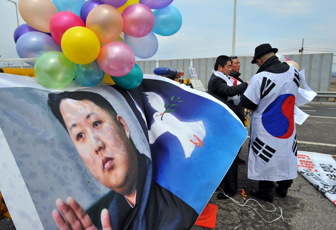 South Korean activists set balloons on a banner showing pictures of North Korean leader Kim Jong-Un. (AFP Photo / Jung Yeon-Je)