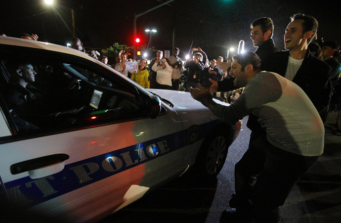 Members of the public cheer as police officers leave the scene where Dzhokhar Tsarnaev, the surviving suspect in the Boston Marathon bombings, was taken into custody in Watertown, Massachusetts April 19, 2013. (Reuters/Brian Snyder)