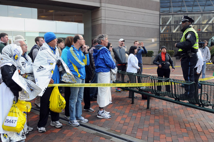 Runners listen to directions from a Boston Police officer at the corner of Stuart Street and Dartmouth Street after two explosive devices detonated at the finish line of the 117th Boston Marathon on April 15, 2013 in Boston, Massachusetts (AFP Photo)