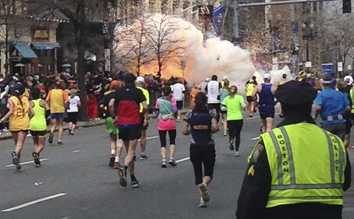 Runners continue to run towards the finish line of the Boston Marathon as an explosion erupts near the finish line of the race in this photo exclusively licensed to Reuters by photographer Dan Lampariello after he took the photo in Boston, Massachusetts, April 15, 2013 (Reuters / Dan Lampariello)