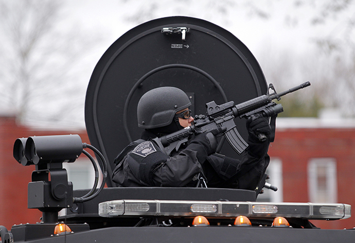A member of the SWAT team trains a gun on an apartment building during a search for the remaining suspect in the Boston Marathon bombings in Watertown, Massachusetts April 19, 2013. (Reuters / Jessica Rinaldi)