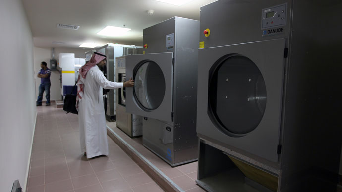 A local media representative looks at a washing machine during a tour of a new centre for the rehabilitation of suspected "terrorists" and potential al-Qaeda recruits in Riyadh on April 9, 2013.(AFP Photo / STR)