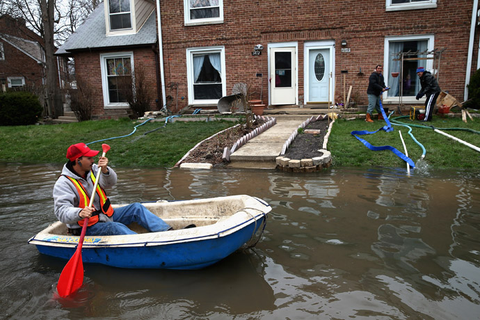 Octavio Castillo paddles a boat down a flooded street to reach the home of his cousin on April 19, 2013 in Des Plaines, Illinois. (Scott Olson/Getty Images/AFP)