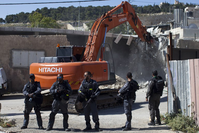 Israeli security officers stand guard as a bulldozer hired by the Jerusalem municipality destroys a Palestinian house in the Israeli annexed East Jerusalem neighborhood of al-Tur on April 24, 2013. (AFP Photo / Ahmad Gharabli)