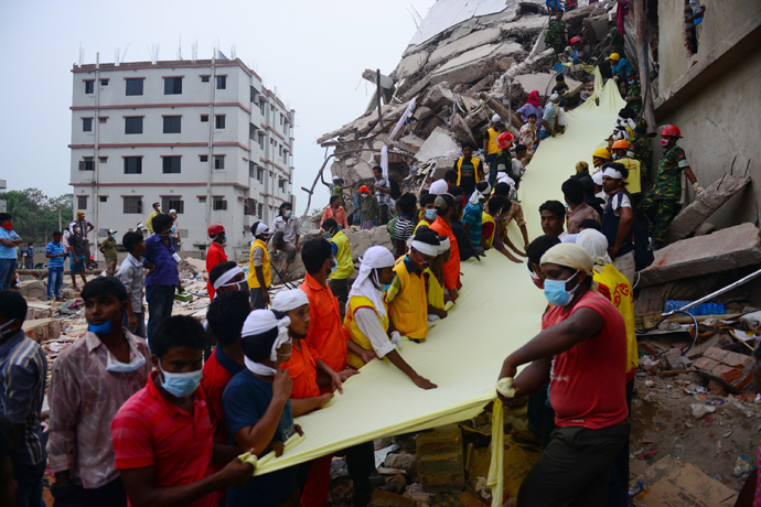 Bangladeshi rescue worker holds a length of textile as a slide to move dead victims recovered 60 hours later, from the rubble of a collapsed eight-storey building in Savar, on the outskirts of Dhaka, on April 26, 2013 (AFP Photo / Muniz Uz Zaman)