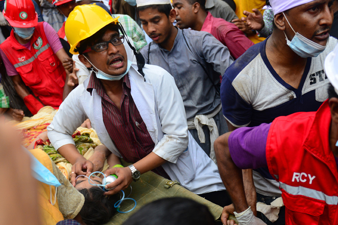 Bangladeshi rescue worker assists a survivor after she was recovered, 60 hours later, from the rubble of a collapsed eight-storey building in Savar, on the outskirts of Dhaka, on April 26, 2013 (AFP Photo / Muniz Uz Zaman)