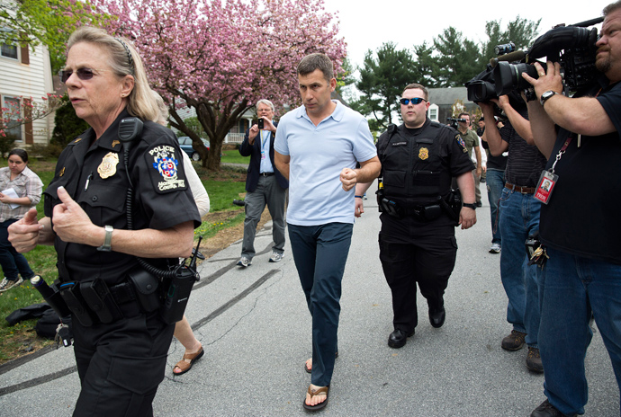 Ruslan Tsarni (C) is escorted by police as he walks to his home after speaking with a neighbor in Montgomery Village, Maryland April 19, 2013 (Reuters / Joshua Roberts)