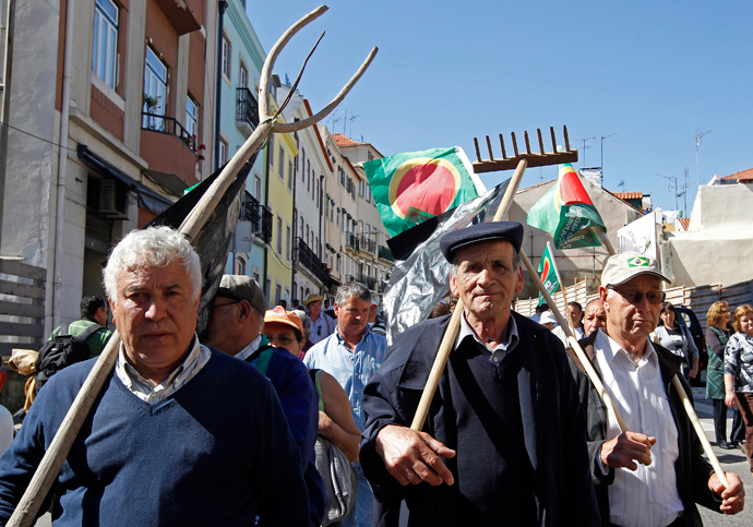 Farmers march to the Parliament in Lisbon with flags and their old tools April 17, 2013 (Reuters / Jose Manuel Ribeiro)